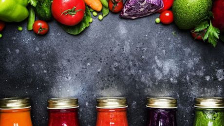 buntes Obst und Gemüse, pur und verarbeitet in Flaschen abgefüllt