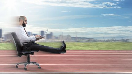 Mann sitzt am B&uuml;rostuhl mit Laptop und flitzt vorbei.