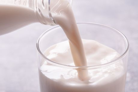 Milch wird in ein Glas eingeschenkt.