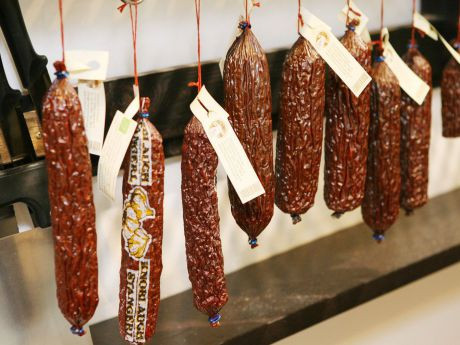 Wurst zum Verkauf h&auml;ngt &uuml;ber der Theke der mass-greisslerei.at